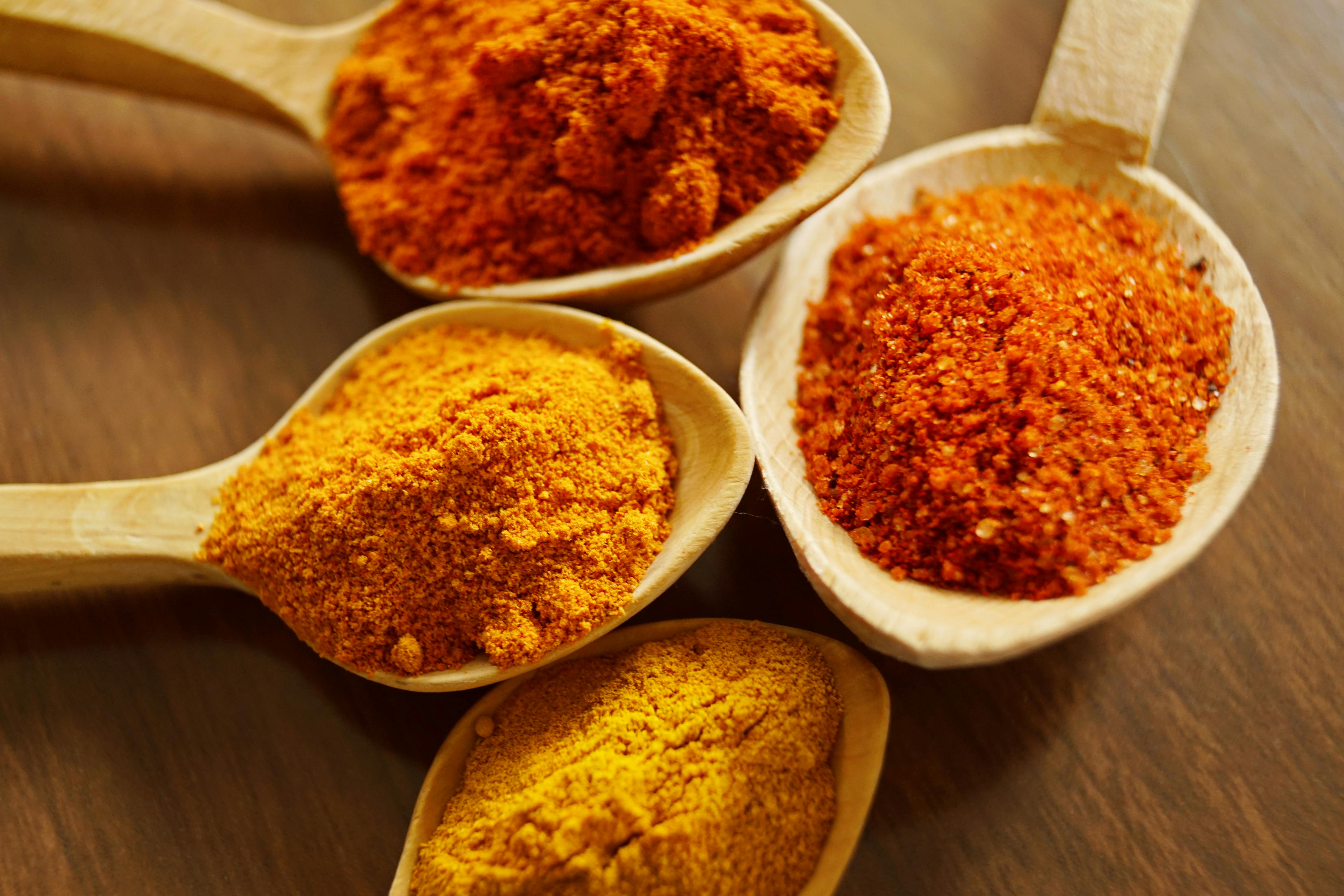 Spice powders in wooden spoons